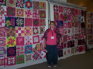 Proud Valerie in front of the blocks that will be made into Opportunity Quilts for next year's QuiltFest.